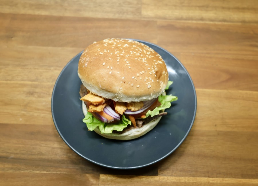Char-grilled chicken burger with lettuce, onion and sauce